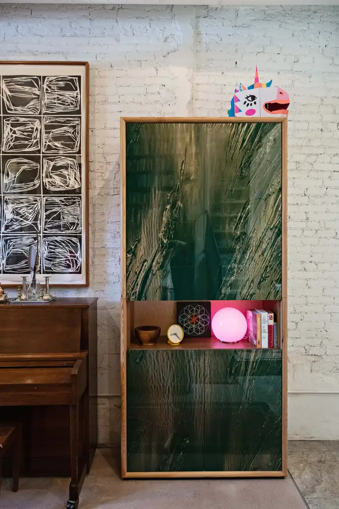 Painted glass cabinet built into a brick wall