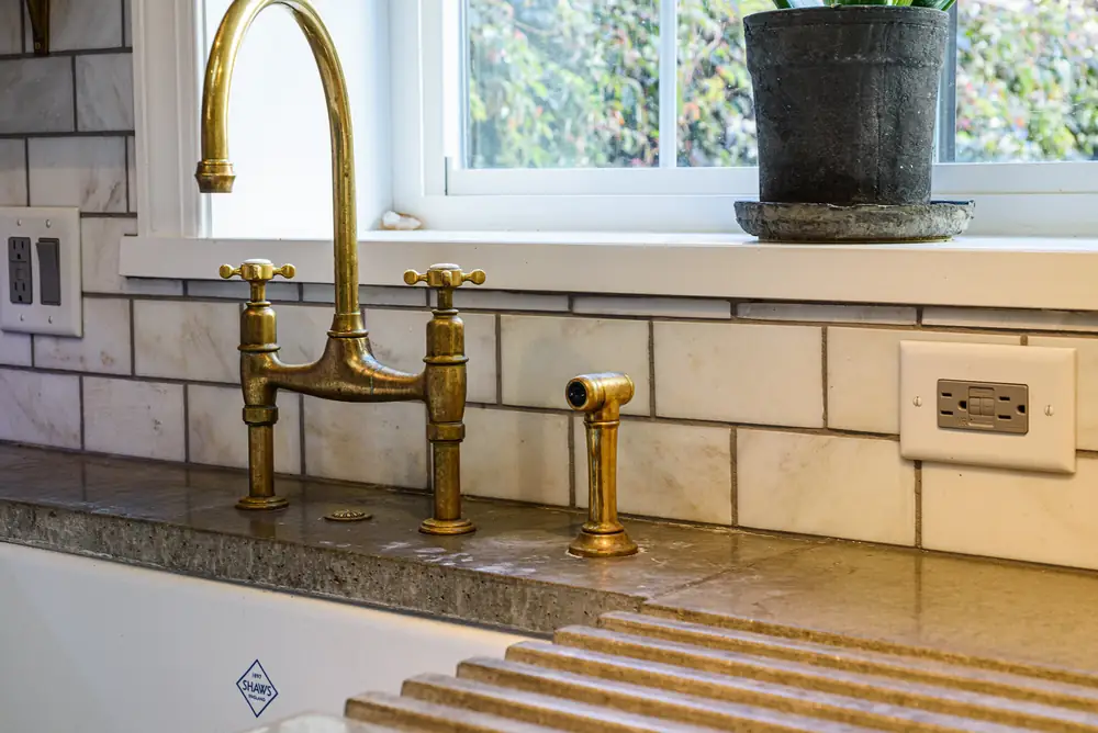 Brass bridge faucet and concrete counter in Mochi's House kitchen