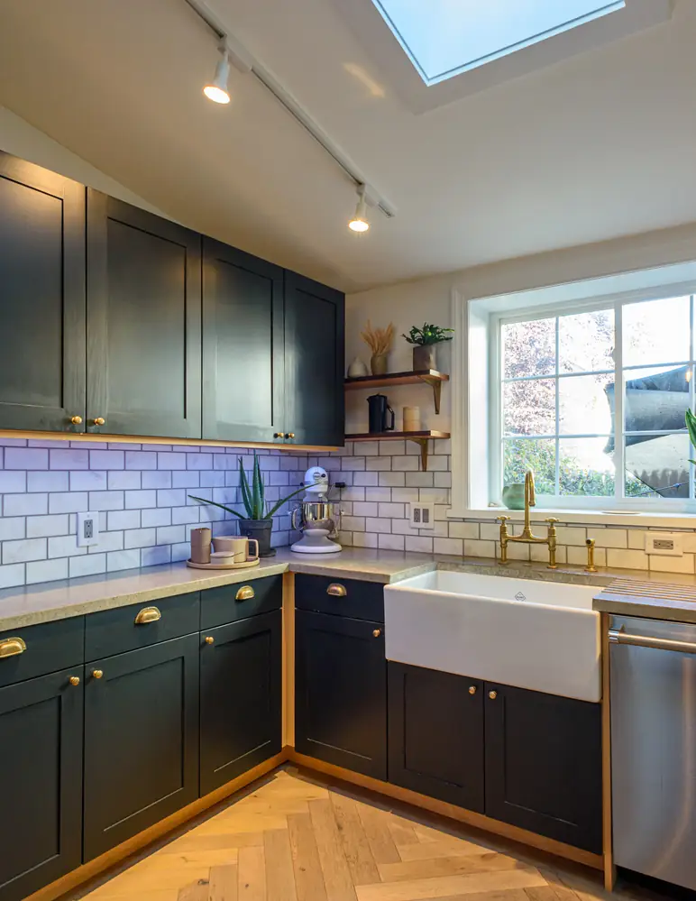 Kitchen with dark cabinetry and brass